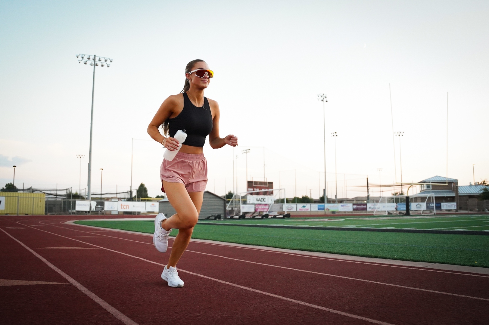 An athlete running on a track at golden hour